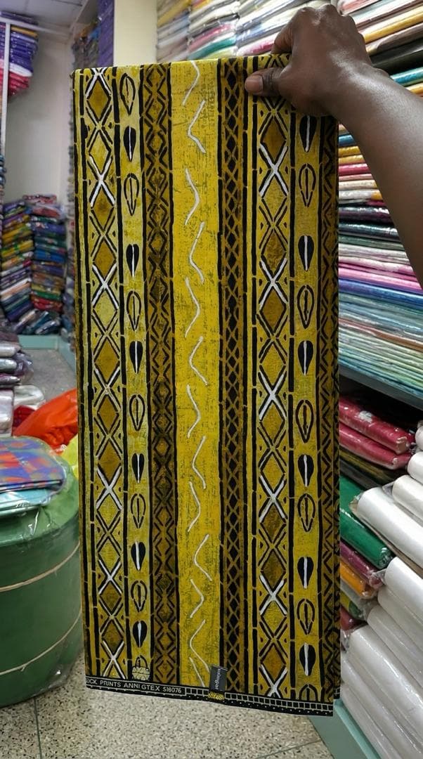 Yellow and black column-print wax — styled as a shirt and wide-leg trousers — the fabric in stock at Zion Vitenge Centre