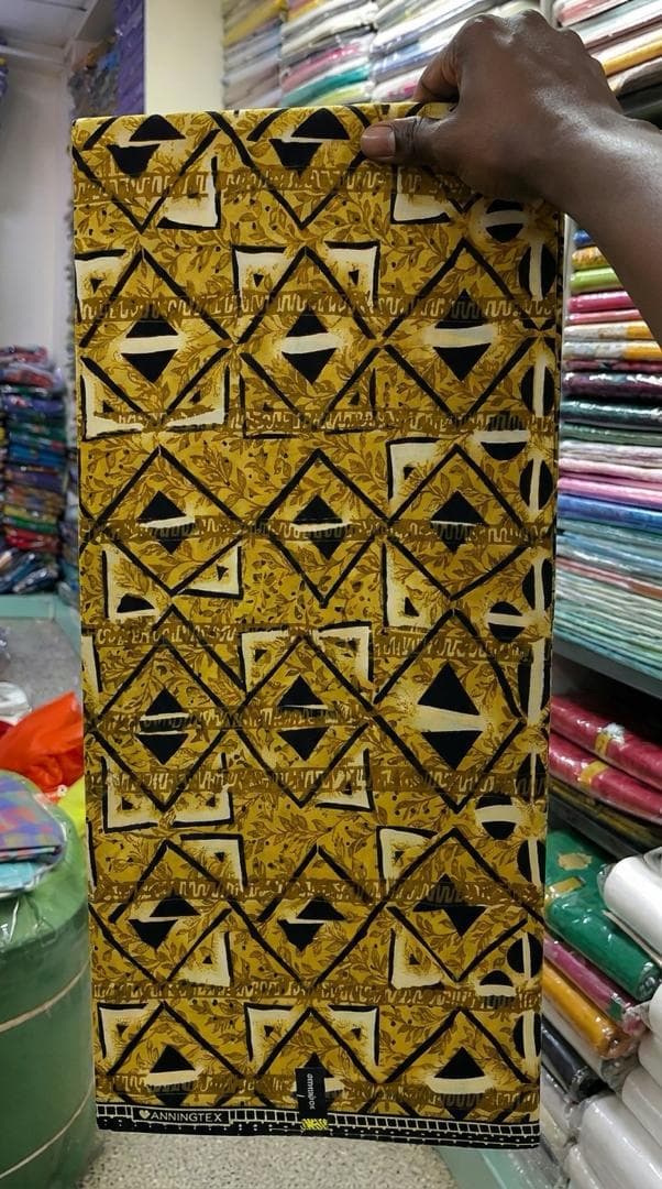 Gold and black diamond print — styled as a shirt with trimmed trousers — the fabric in stock at Zion Vitenge Centre